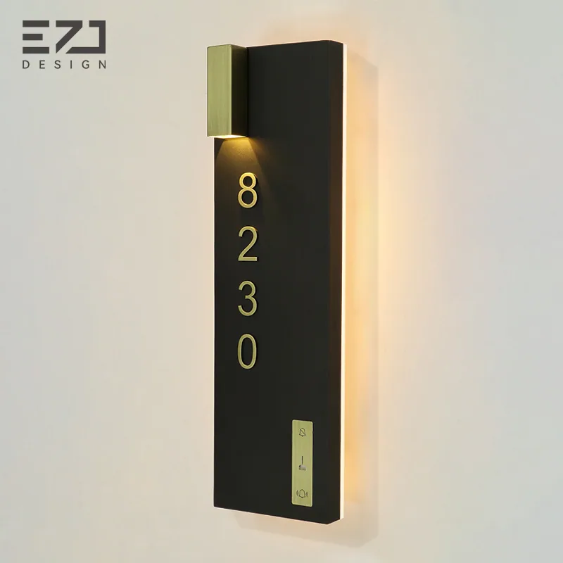 Angled view of the black and gold-colored illuminated hotel door sign