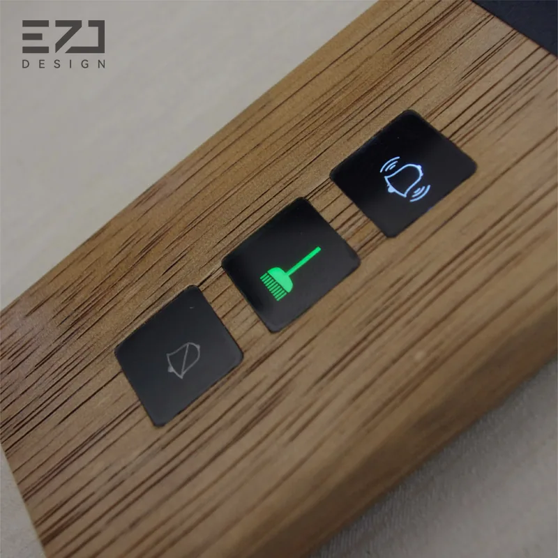 Close view of three visible status controls on a wood-look hotel room sign